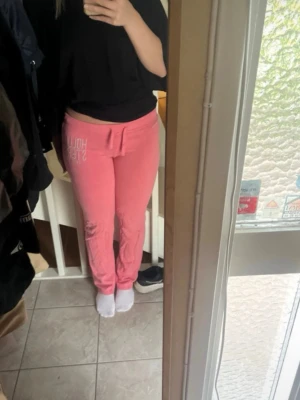 Rosa mjukisbyxor från Hollister - Snygga lågmidjade mjukisbyxor från Hollister. Sitter tight hela vägen fram till vaderna. 
