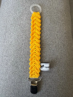 Virkad napphållare - Virkad, solros gul napphållare, virkad av mig i 100% bomullsgarn med metallclips och silikonring.  Mönsterskapare: animo.design