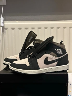 Nike Air Jordan 1 Mid Svart/Vit - Nike Air Jordan 1 mid. Säljer skorna för dem är för smala för mina fötter.Har provat dem några gånger men har aldrig använt dem.