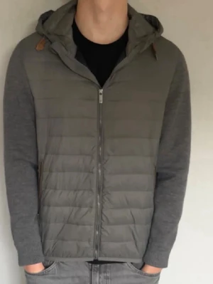 Massimo Dutti Cardigan - Snygg grå jacka med quiltad front och stickade ärmar. Jackan har huva med dragsko och dragkedja framtill. Perfekt för lager-på-lager och chill stil.