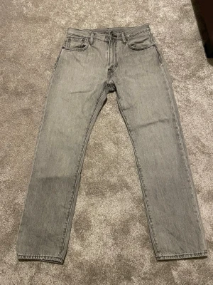 Levis jeans grå - Säljer nu dessa snygga Levis jeans i färgen grå. Jeansen är stright fit men skulle säga att de sitter lite loose. Storleken är 30/32 men skulle säga att de sitter lite tajtare i midjan. Hör av er vid frågor!
