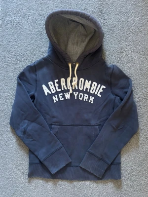 Vintage Abercrombie & Fitch Hoodie - Säljer denna as feta abercrombie&fitch hoodien | Storlek S | Mycket bra skick förutom ett hål p högra ärmbågen, syns knappt se sista bild | Längd ≈ 64cm, bredd armhåla-armhåla ≈53cm | Modell 175cm, 68kg