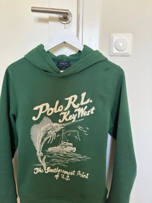Grön key west hoodie  - Säljer en grön key west hoodie ifrån Polo Ralph Lauren. Tröjan är i bra skick och sällan använd. Storlek 14-16 år. Endast seriösa bud. Skriv om ni har några frågor Mvh Lusso Studio⚜️