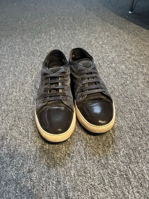 Lanvins  -  Skick: Mycket bra Storlek: 43 Färg: Marinblå/mörkblå  Säljer ett par Lanvin skor som är enkla att matcha och funkar till det mesta. Skorna är i mycket bra skick och välskötta. Det finns en liten slitning som syns på bild 5, men inget som påverkar helheten alls. Lanvin skorna är även självklart äkta och originalpåsen medföljer. Skriv gärna vid frågor eller om du vill ha fler bilder! 