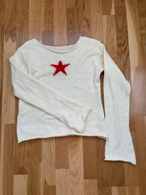 Vit stickad tröja med röd stjärna - Köpt på camden market i london💞Vit beige stickad tröja med lång ärm och rund halsringning. På bröstet finns en röd stjärna som ger en cool kontrast till den ljusa färgen. Tröjan har en rak passform och är tillverkad i ett mjukt, tunt stickat material. Aldrig använd därav priset, nypris är ca 300 kr. Står storlek XL men är verkligen inte det, skulle mer säga S/M eller one size💞