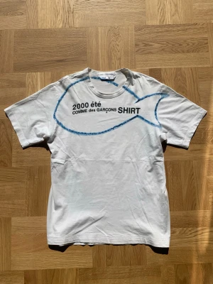 Comme des Garçons SHIRT ss/00 - Extremt sällsynt t-shirt från Comme des Garçons SHIRT spring/summer collection år 2000. Mycket fint med tanke på åldern, minimala fläckar som visas på sista bilden men överlag mycket bra skick. Storlek L men passar som M, utgå från angivna mått:  Längd (ryggrad): 66 Bredd (över bröstet): 46  Skriv vid frågor eller funderingar! /william
