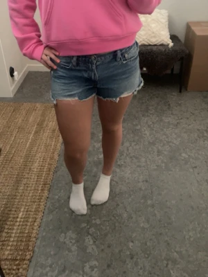 Blå jeansshorts med fransig kant - Blåa jeansshorts 