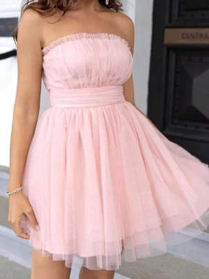 Axelbandslös rosa tyllklänning - Söt axelbandslös kort klänning i ljusrosa tyll med voluminös kjol och markerad midja. Klänningen är helt ny då jag råkade beställa 2 stycken😊Pris kan alltid diskuteras! 