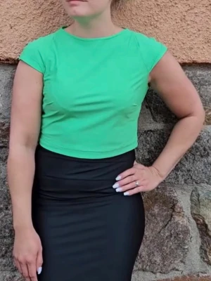 Grön croppad topp med kort ärm - Snygg croppad topp i klargrönt med korta ärmar och rund halsringning. Perfekt till höga jeans eller kjol för en fräsch look. Tunt och mjukt material som känns skönt mot huden.