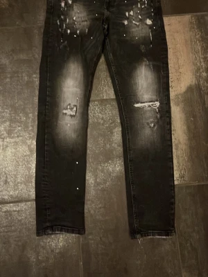 Supply and demand jeans - Säljer ett par svarta jeans med slitningar från supply and demand. Jeansen har slim fit och tvättade partier. Bra skick.