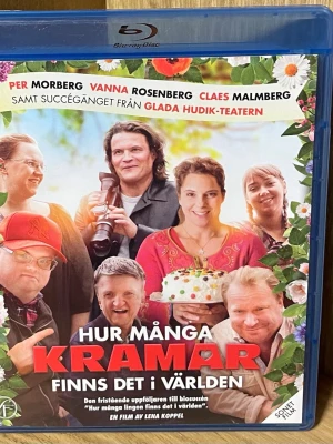 Hur många kramar finns det i världen Blu-ray - Blu-ray-film med titeln 'Hur många kramar finns det i världen'. Svensk romantisk dramakomedi med humoristiska inslag. Omslaget är färgglatt med blommor och bilder på skådespelarna. Filmen är en fristående uppföljare till 'Hur många lingon finns det i världen'.