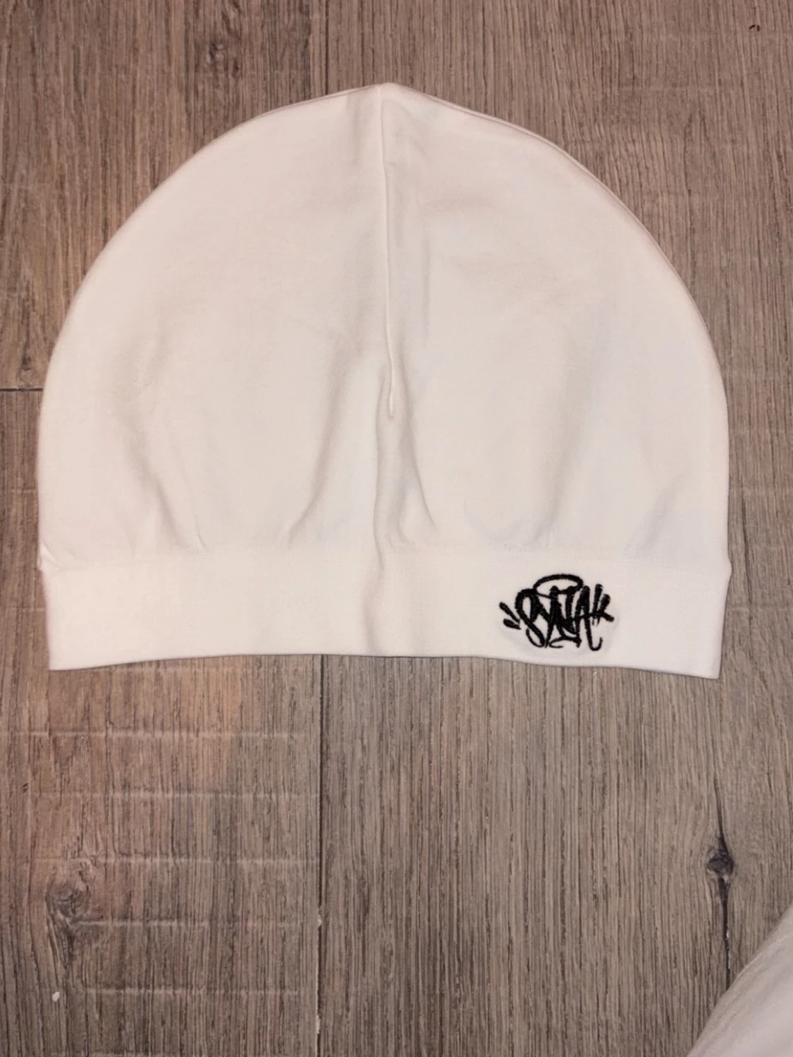 Vit syna world skull cap med svart broderad logga
