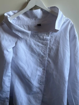 Vit skjorta med bred krage - Klassisk vit skjorta från Zara med bred, markerad krage och knappar framtill. Skjortan har lång ärm och är tillverkad i bomull för en skön och luftig känsla. Perfekt för dig som gillar stilrena och enkla plagg.