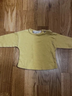 Gul barn / baby tröja från Zara - Storlek 62 - Gul långärmad babytröja från Zara säljes! Perfekt i vardagen för de allra minsta! Storlek: 62 (1–3 månader) Säljs i bra skick! Kika gärna in på mina andra annonser, jag säljer just nu flera barnplagg!