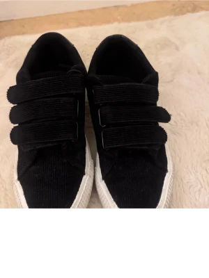 Skor  - Ett par skor med carborre band och svart ribbad mocka storlek 38 och knappt andvända.  Köpte dem här på Plick 