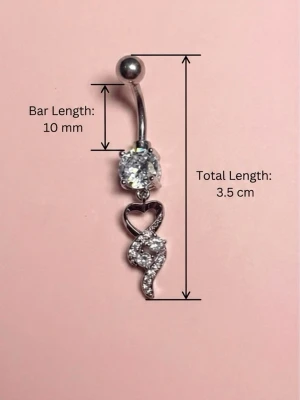 ✨ NY oanvänd navelpiercing med hänge - Kirurgiskt stål 316L  - ✨ NYTT oanvänt smycke i kirurgiskt stål! 🌸 Hållbart & Rostfritt: Slitstarkt 316L-stål som inte oxiderar eller rostar av fukt. 🌸 Säkert: Industristandard, skonsamt för läkta piercingar.  🛍️ 30 % BUNDLE-RABATT! Köp fler artiklar från min shop och få 30 % på allt! ✨ 📦 Frakt: Endast spårbart via Plick SafePay för vår trygghet.