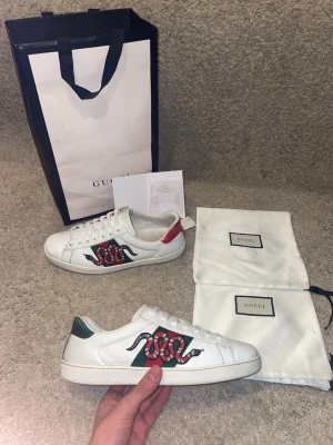 Gucci Ace "Kingsnake" kvitto finns  - Hej! Säljer nu mina klassiska Gucci Ace sneakers med Kingsnake-broderi. Storlek 7.5 (motsvarar ca 41.5-42 i Gucci-storlek). Skicket är 8.5/10. Nypris ca 8200 kr, säljs för 3399 kr! Allt OG (dustbags och påse) samt kvitto medföljer vid köp. En tidlös lyxsneaker som passar till allt. Passa på!