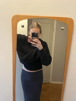 Långkjol - Säljer en enkel och stilren mörkgrå långkjol i ett stretchigt och mjukt material. Kjolen har en tight passform och är perfekt för dig som gillar minimalistisk stil. Passar till många olika outfits och är superbekväm att bära.