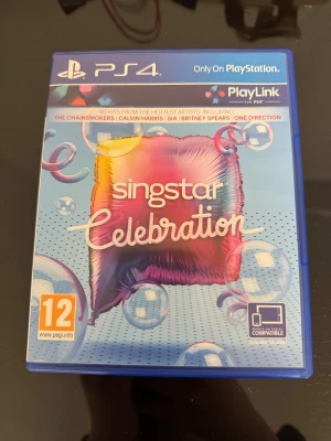 Singstar Celebration till PS4 - Singstar Celebration till PS4 är ett partyspel där du sjunger med till hits från artister som The Chainsmokers, Calvin Harris och Sia. Spelet kommer i ett blått plastfodral med färgglad framsida och matchande skiva. Perfekt för dig som gillar musikspel och PlayLink.