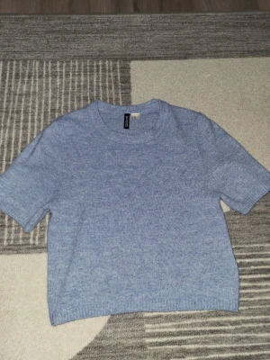 Stickad kortärmad tröja - Ljusblå stickad kortärmad tröja. Från HM, divided och knappt använd- har därför inga skador. Perfekt för hösten/våren när det inte är fär kyligt ute.
