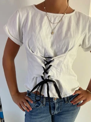 Vit tröja med snörning - Skit snygg och populär tröja med knytning där fram. Kortärmad och figurnära passform som markerar midjan. Skriv för mer frågor eller bilder🩷🩷🩷pris kan diskuteras vid snabb affär