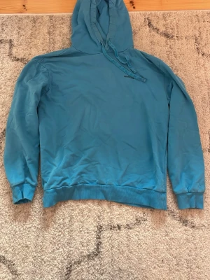 Blå hoodie  - Snygg blå hoodie med klassisk huva . Tröjan har ribbade muddar vid ärmslut och nederkant samt en relaxed fit. Perfekt för en chill och avslappnad stil. Materialet känns mjukt och bekvämt mot huden.