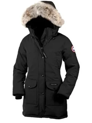 Svart parkas från Canada Goose - Svart parkas från Canada Goose med klassisk pälsbeklädd huva och logotyp på ärmen. Jackan har stora fickor framtill, dragkedja och knappar, samt en längre passform som skyddar mot kyla. Perfekt för kalla vinterdagar.
