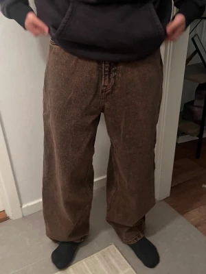 Bruna baggy jeans  - 400 kr originalpris, säljer för 200. bruna baggy jeans med bred passform och tvättad vintage-look. Jeansen har hög midja och raka ben, Materialet är denim i bomull. Inga synliga loggor eller märken. Funkar för båda kön. NY 