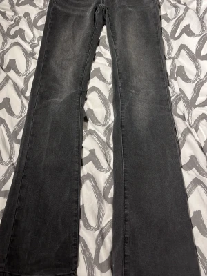 Svarta bootcut-jeans med brodyr madlady TALL - Säljer ett par svarta bootcut-jeans med snygg broderad detalj på bakfickan. Jeansen har en lätt tvättad look och klassisk femficksdesign. Perfekta för dig som gillar en retrostil och vill ha ett par jeans som sticker ut lite extra. Från madlady TALL