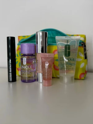 Clinique skönhetskit med necessär - Säljer ett färgglatt skönhetskit från Clinique med necessär. Innehåller mascara, makeup remover, chubby stick, fuktgel och fuktkräm. Perfekt för dig som vill testa flera produkter från Clinique. Necessären är gul med blommönster och turkos dragkedja. Hela kitet är oanvänt!