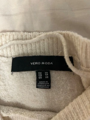 Beige stickad tröja Vero Moda XS - Söt beige stickad tröja från Vero Moda i storlek XS. Tröjan har puffärmar och ribbade muddar vid ärmslut och nederkant. Perfekt för dig som gillar en enkel men trendig look.