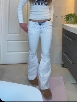 Vita bootcut diesel jeans med snörning - Säljer ett par vita bootcut jeans med snygg snörning i midjan, låg midja. Jeansen har detaljer med slitningar framtill. Dragkedjan är trasig men snörningen döljer. Säljs då de är små för mig. Storlek xs/xxs