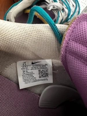 Nike Dunk Low Off-White Lot 21 - Nike Dunk Low Off-White Lot 21 med vit och grå ovandel i mocka och läder, detaljer i lila och gult samt turkosa extra snören. Snygg Off-White branding på hälen och unik etikett på plösen. Perfekta för dig som vill sticka ut med en limiterad sneaker. Cond 5/10, har screen från raffle.