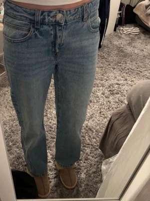 Ljusblå straight baggy jeans - Säljer ett par ljusblå raka jeans med snygga paljettdetaljer på bakfickorna. Jeansen har klassisk femficksmodell, låg midja och är gjorda i denim. Perfekta för dig som vill ha en chill men ändå unik look.