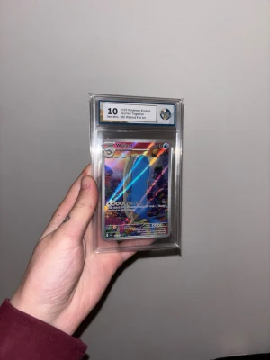 Pokémonkort Wailord Full Art 2023 - Säljer ett Pokémonkort från 2023, Wailord Full Art, engelskt och graderat till 10 Gem Mint. Kortet har färgglad holografisk design och ligger i ett skyddande plastfodral. Perfekt för samlare eller Pokémonfans. Scarlett & violett Journey together. Skickas välpackat och säkert. 