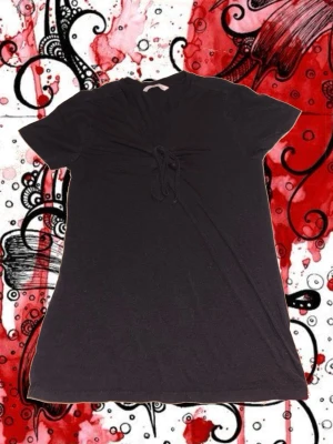 Svart topp med knyt framtill - En svart topp med korta ärmar och knyt framtill vid bysten. använd få gånger.