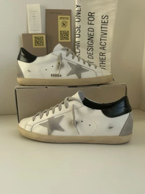 Golden Goose vita och grå sneakers - | Säljer ett par snygga Golden Goose skor | skorna är i mycket bra skick | storleken är 43 men passar även 42 | priset kan diskuteras!!!!