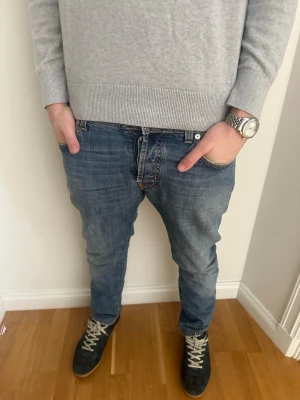 Blåa Jacob Cohen jeans - Säljer ett par klassiska blå jeans från Jacob Cohen med rak passform och snygg tvätt. Jeansen har fem fickor, kontrastsömmar och en orange patch bak i linningen. 