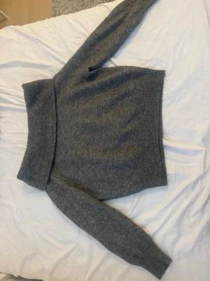 Grå stickad off shoulder från H&M - Säljer pga ingen användning. Använd väldigt fåtal gånger. Varm och mysig. 