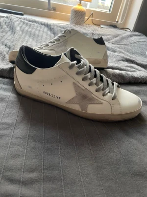 Golden Goose Superstar vita sneakers - Golden Goose Superstar sneakers i vitt läder med grå mockastjärna på sidan. Perfekta nu inför våren