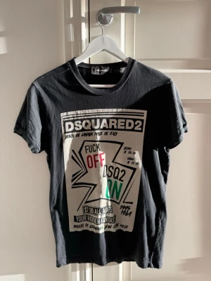 Svart DSQUARED2 t-shirt med tryck - Cool svart t-shirt från DSQUARED2 med stort grafiskt tryck i vitt, rött och grönt framtill. Klassisk rund hals och korta ärmar. 