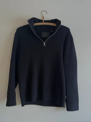 Svart halvzip-tröja jack&jones Premium - Stilren svart stickad tröja från Axel Arigato med halvzip och hög krage. Tröjan har lång ärm och är tillverkad i ett mjukt, strukturerat material som ger en clean look. Perfekt för lager-på-lager och enkel att matcha.