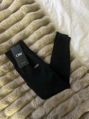 Svarta seamless tights från ICANIWILL - Säljer ett par svarta seamless tights från ICANIWILL i storlek XS. De har hög midja och är tillverkade i ett stretchigt material som sitter skönt på kroppen. Perfekta för träning eller chill dagar. Diskret logga framtill.