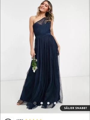 Marinblå långklänning oneshoulder - Super snygg one shoulder klänning och är helt oanvänd med lappen kvar. Köpt 2023 så finns ej att köpa nu. Säljer i storlek ca S-M (uk 10) 