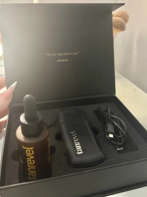 Tanrevel brun utan sol kit - Säljer ett komplett Tanrevel brun utan sol kit med en svart spraytan-enhet, brun vätskeflaska med pipett och USB-laddningskabel. Allt kommer i en snygg svart box med Tanrevel-logga i guld. Perfekt för enkel och smidig self-tanning hemma. Färgen är i ( cool dark ) det är väldigt lite kvar i den!