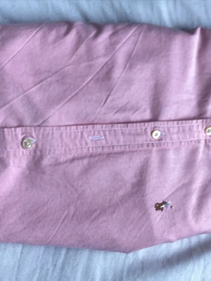 Ralph Lauren skjorta barn – rosa - Ralph Lauren skjorta barn – rosa  Säljer en rosa Ralph Lauren-skjorta i storlek 12 år. Klassisk modell med broderad logga. Skjortan är i fint skick utan hål eller fläckar.  Pris: 150 kr  Finns att hämta eller kan skickas.