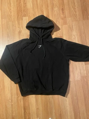 Svart Gymshark Training Oversized Fleece Hoodie – strl S - Säljer en svart Gymshark hoodie i storlek S. Mycket bra skick, inga defekter eller fläckar – bara lite skrynklig efter förvaring 😊 Mjuk och skön fleece, oversized passform och perfekt både till träning och vardag.  Nypris: 449 kr Säljes pga kommer tyvärr inte till användning. Hör av er vid frågor eller funderingar!💕