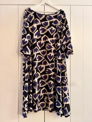 Mönstrad långklänning i blått och svart - Klänning (vadlång) från Masai i storlek XXL. Fint och unikt mönster, luftigt och kallt material (Viskos 100%). Mycket bra skick, förekommer med en defekt - knapphålet har lossnat (går nog att fixa enkelt)  Nypris: 1299kr