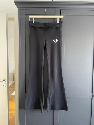 Svarta True Religion yogapants- xs  - Snygga utsvängda yogapants från True Religion i storlek XS. Använda fåtal ggr, har fåtal sprickor i hästskon (se bild), inget man tänker på dock! Nypris 599kr. Skriv vid frågor, öppen för prisförslag 💕