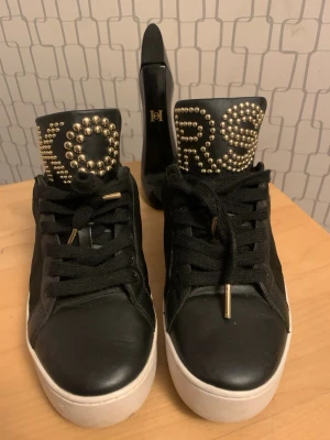 Svarta Michael Kors  - Snygga svarta sneakers från Michael Kors Äkta och luktfritt. Använd några gånger. Står KORS i guldfärg. 